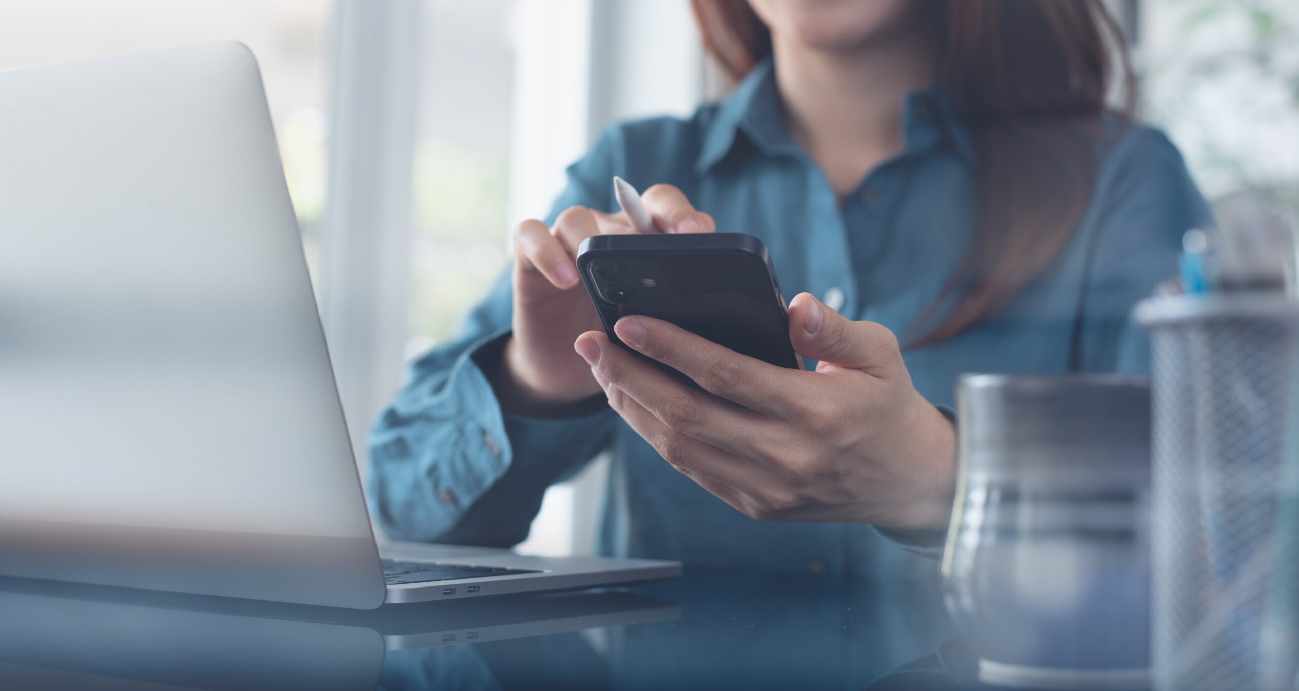 Businesswoman,Using,Mobile,Smart,Phone,During,Working,On,Laptop,Computer